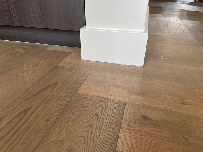 Houten vloer, detail plint, parket elleboog patroon, Den Haag